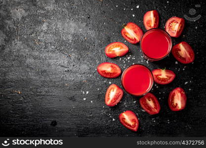 Fresh tomato juice. On a black background. High quality photo. Fresh tomato juice. On a black background.