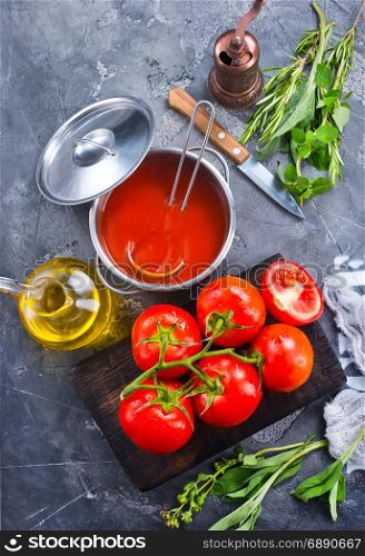 fresh tomato soup and tomato on kitchen table