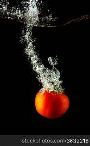 fresh tomato uder water on black background