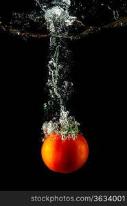 fresh tomato uder water on black background