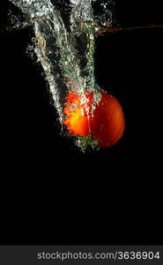 fresh tomato uder water on black background