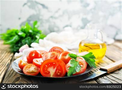 fresh tomato with salt and basil on the kitchen table