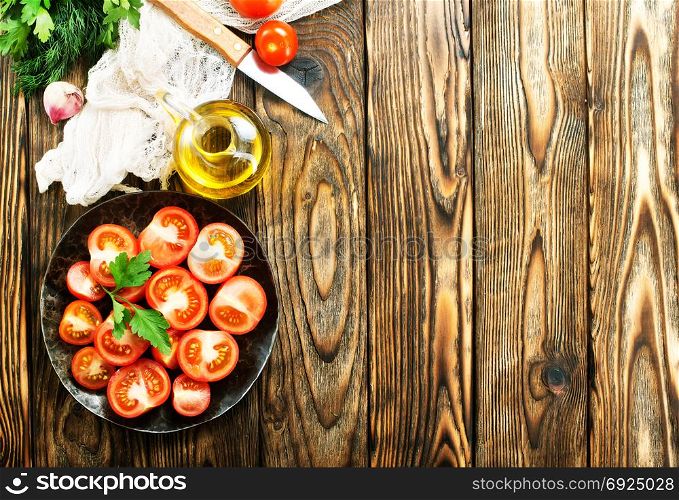fresh tomato with salt and basil on the kitchen table
