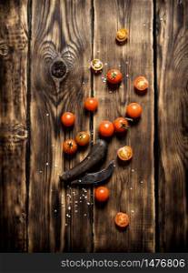 Fresh tomatoes and an old knife. On wooden background.. Fresh tomatoes and an old knife.