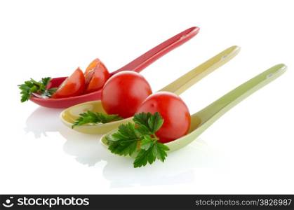 Fresh tomatoes and parsley leaves on ceramic spoons.