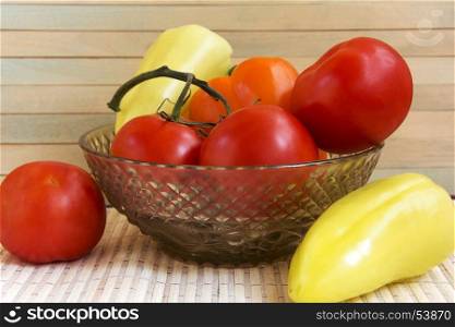 Fresh tomatoes and pepper in a glass vase
