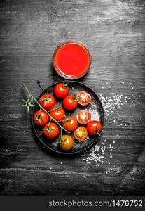 Fresh tomatoes and tomato sauce . On black rustic background.. Fresh tomatoes and tomato sauce .