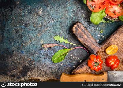Fresh tomatoes, cutting board and kitchen knife on dark rustic background, top view, place for text