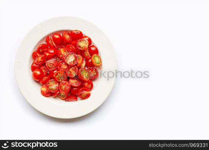 Fresh tomatoes, half cut on white dish. Copy space