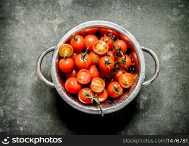 Fresh tomatoes in the bowl. Wet stone background. . Fresh tomatoes in the bowl.