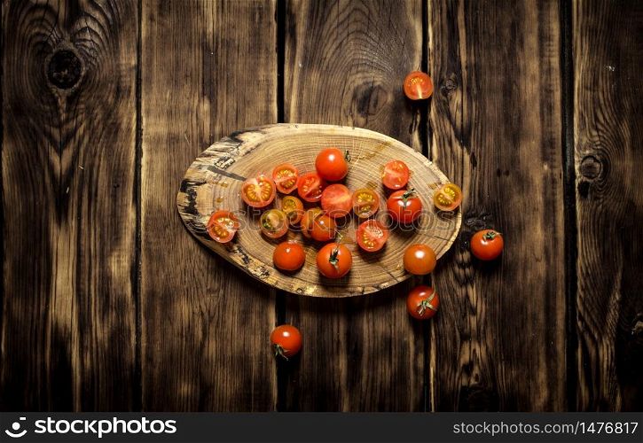 Fresh tomatoes on a wooden trunk. On wooden background.. Fresh tomatoes on a wooden trunk.
