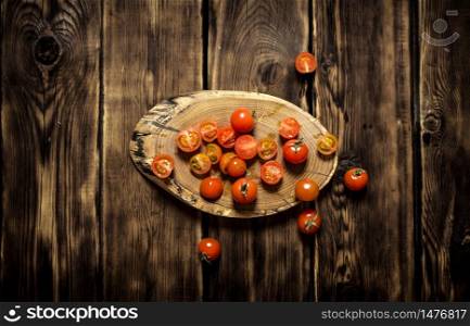 Fresh tomatoes on a wooden trunk. On wooden background.. Fresh tomatoes on a wooden trunk.
