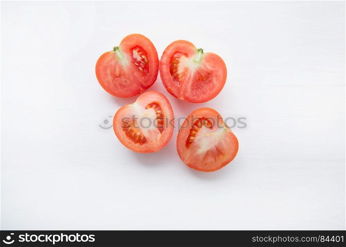Fresh tomatoes slices on white wooden background.