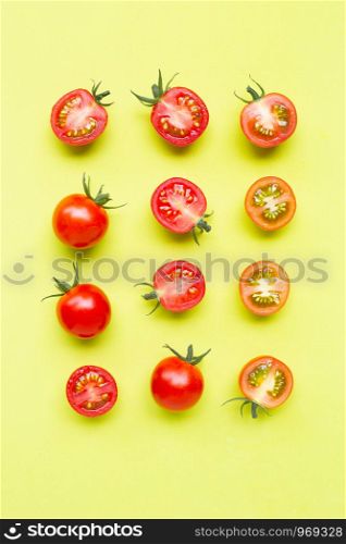 Fresh tomatoes, whole and half cut isolated on green background. Top view