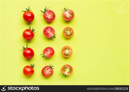 Fresh tomatoes, whole and half cut isolated on green background. Top view