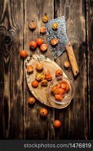 Fresh tomatoes with a hatchet for cutting. On wooden background.. Fresh tomatoes with a hatchet for cutting.