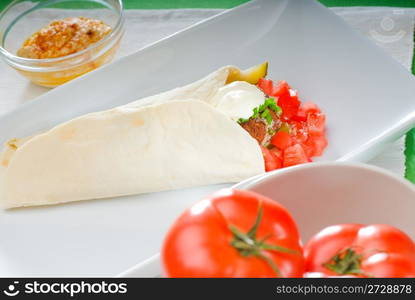 fresh traditional falafel wrap on pita bread with fresh chopped tomatoes