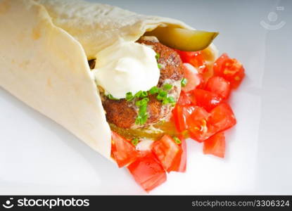 fresh traditional falafel wrap on pita bread with fresh chopped tomatoes