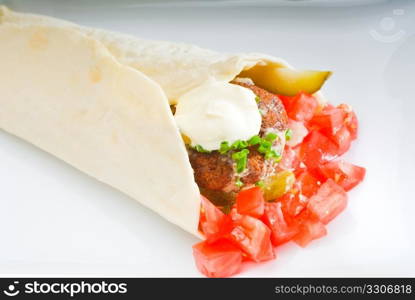 fresh traditional falafel wrap on pita bread with fresh chopped tomatoes