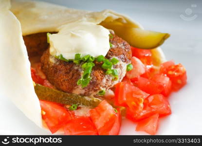 fresh traditional falafel wrap on pita bread with fresh chopped tomatoes