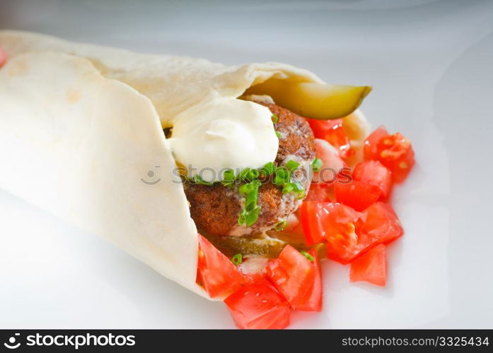 fresh traditional falafel wrap on pita bread with fresh chopped tomatoes