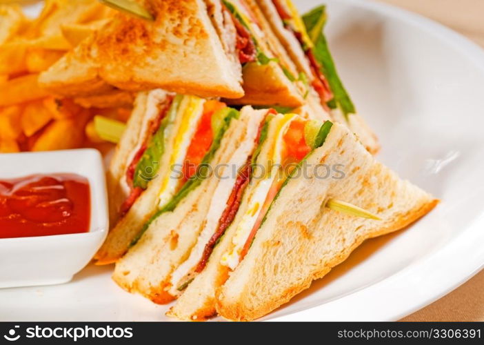 fresh triple decker club sandwich with french fries on side