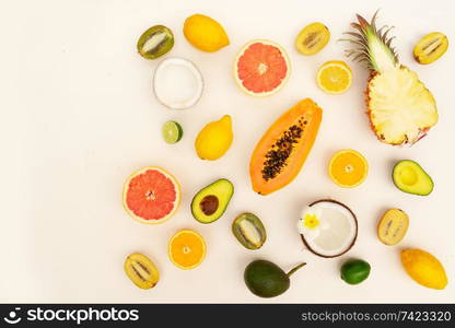 fresh tropical fruits halves food pattern flat lay scene, summer diet border with copy space. Summer diet, fresh fruits