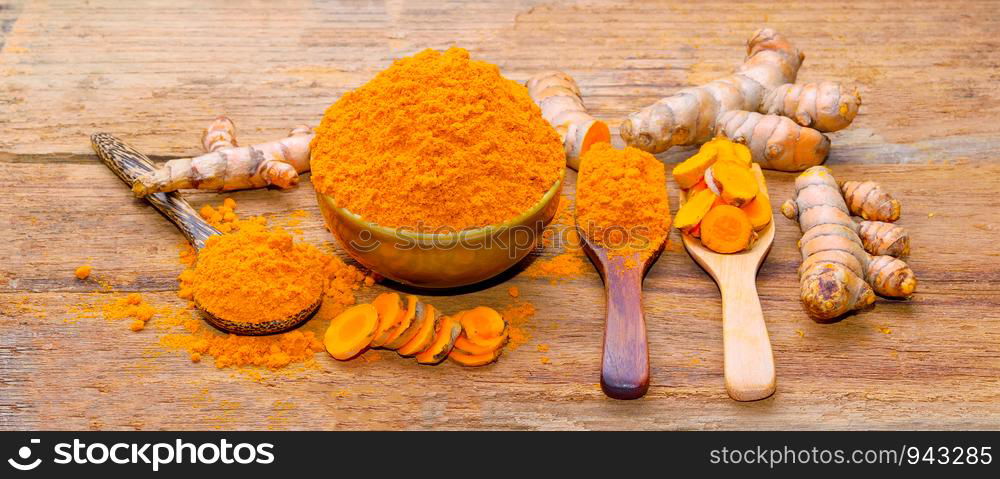 fresh turmeric roots on wooden table