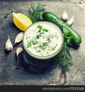 Fresh tzatziki yogurt sauce. Herbs and vegetables. Vintage style toned picture