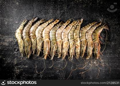 Fresh uncooked raw shrimp. On a black background. High quality photo. Fresh uncooked raw shrimp. On a black background.
