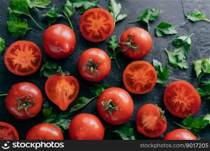 Fresh ve>ab≤s on dark background. Ripe red tomatoes and green pars≤y harvested from garden. Water drops on organic∏ucts. Tasty vegan∏ucts