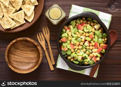 Fresh vegan chickpea, celery, grape and apple salad with parsley, homemade sesame pita chips and vinaigrette on the side, photographed overhead with natural light. Chickpea, Celery, Grape and Apple Salad