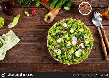 Fresh vegan vegetable salad of radish, cucumbers, lettuce, dill and green onion, healthy vegetarian food