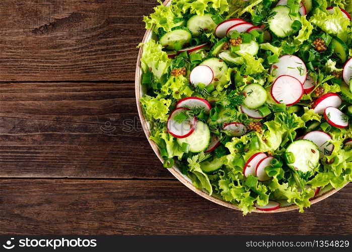 Fresh vegan vegetable salad of radish, cucumbers, lettuce, dill and green onion, healthy vegetarian food