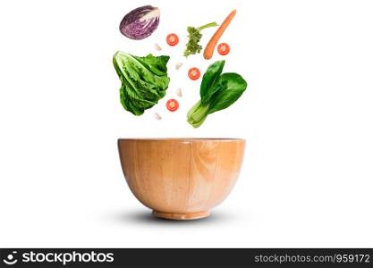 fresh vegetable falling to wooden bowl