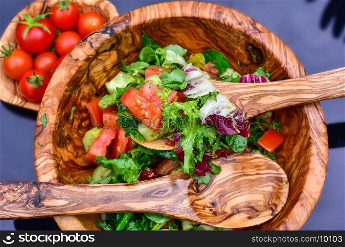 Fresh vegetable salad and wooden tableware
