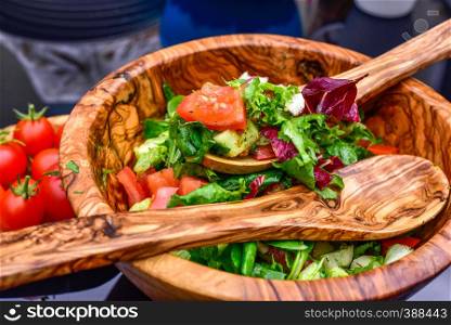 Fresh vegetable salad and wooden tableware