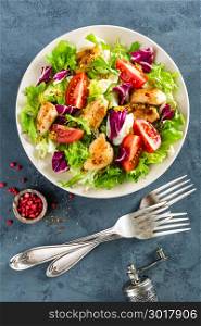 Fresh vegetable salad bowl of tomatoes, cucumbers, italian mix, lettuce and grilled chicken breast on table. Fried chicken meat, fillet with salad. Healthy food. Diet dinner or lunch menu. Flat lay. View from above