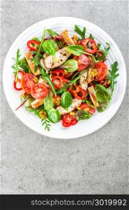 Fresh vegetable salad plate of tomatoes, spinach, pepper, arugula, chard leaves and grilled chicken breast. Fried chicken meat, fillet with salad. Healthy food. Diet dinner or lunch. Salad plate on table. top view with space for a text