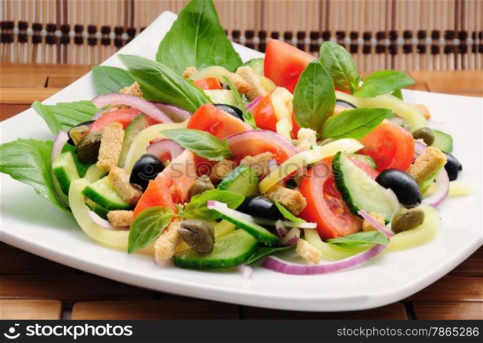 Fresh vegetable salad with basil, capers, olives, marinated with croutons