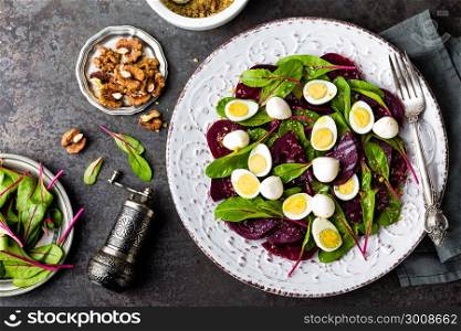 Fresh vegetable salad with boiled beet, mangold leaves, walnuts and quail eggs