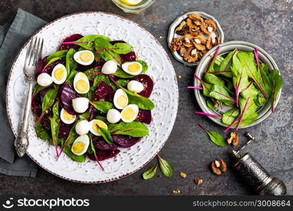 Fresh vegetable salad with boiled beet, mangold leaves, walnuts and quail eggs