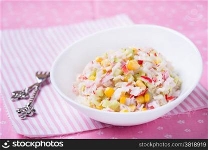 Fresh vegetable salad with corn, cabbage, crab and mayonnaise, selective focus