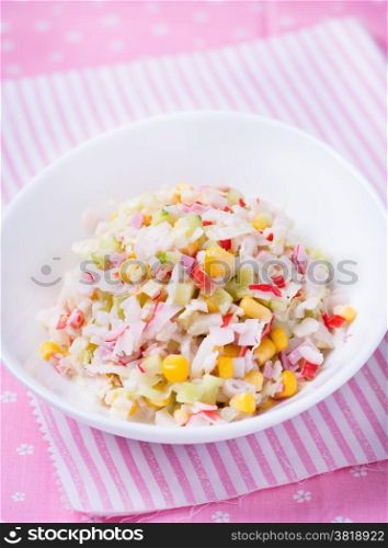 Fresh vegetable salad with corn, cabbage, crab and mayonnaise, selective focus