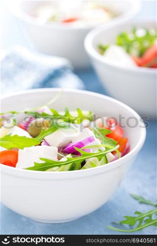 Fresh vegetable salad with feta cheese and olives in white bowl. Greek cuisine