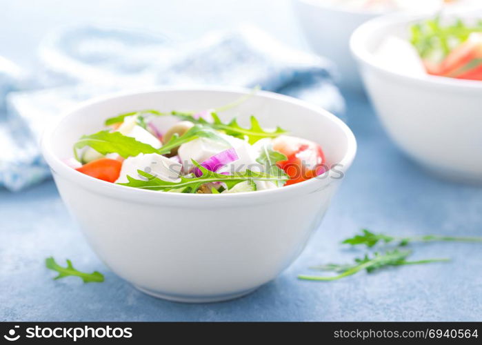 Fresh vegetable salad with feta cheese and olives in white bowl. Greek cuisine