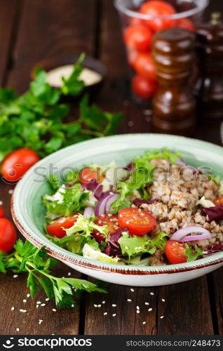 Fresh vegetable salad with lettuce, onion, tomatoes and buckwheat porridge. Healthy vegan food