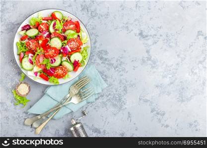 Fresh vegetable salad with tomatoes, cucumbers, sweet pepper and sesame seeds. Vegetable salad on white plate