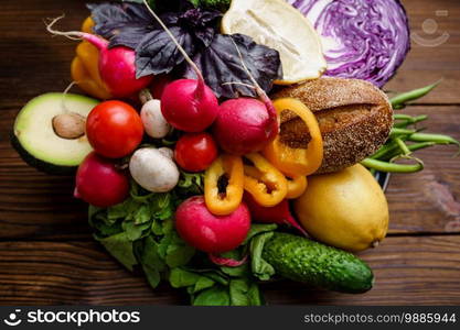 Fresh vegetable set on wooden background. Organic vegetarian food, grocery assortment, natural products, healthy lifestyle concept. Fresh vegetable set isolated on wooden background