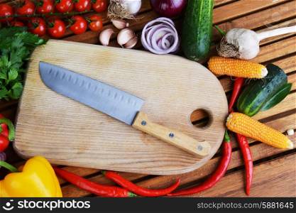 fresh vegetables and cutting board on wooden background
